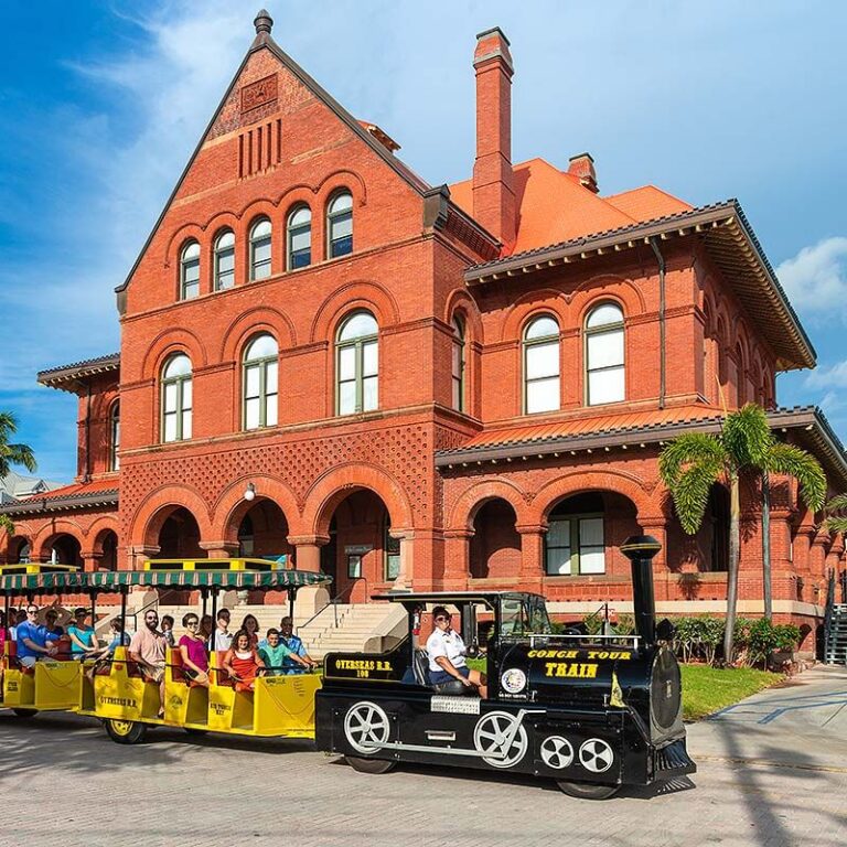 Conch Tour Train driving by Key West Custom House