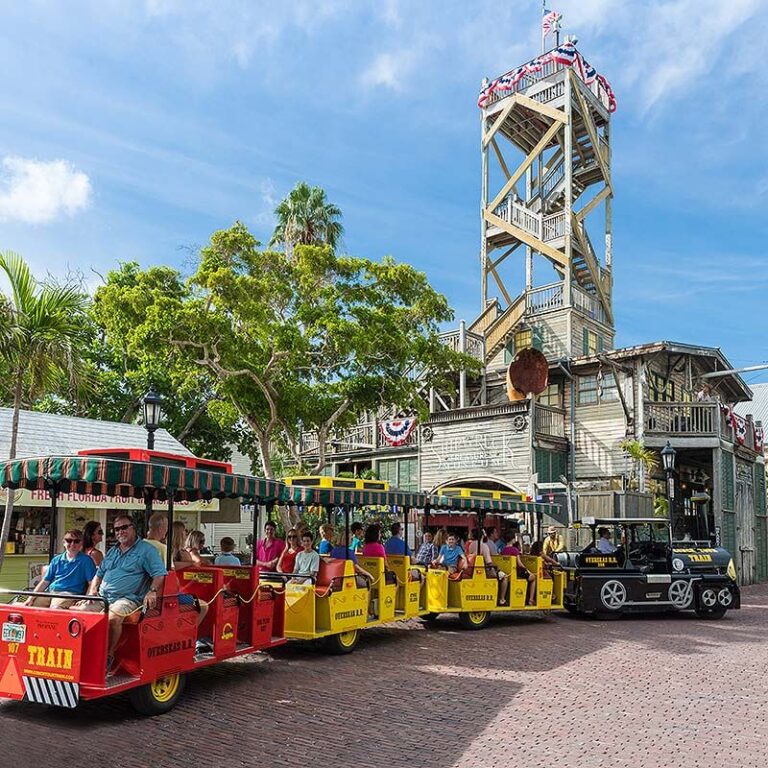 Conch Tour Train driving by Key West Shipwreck Treasure Museum