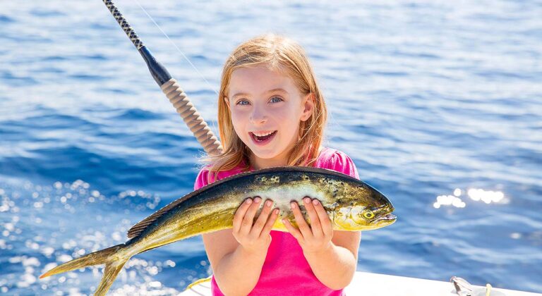 girl holding tuna fish during fishing expedition